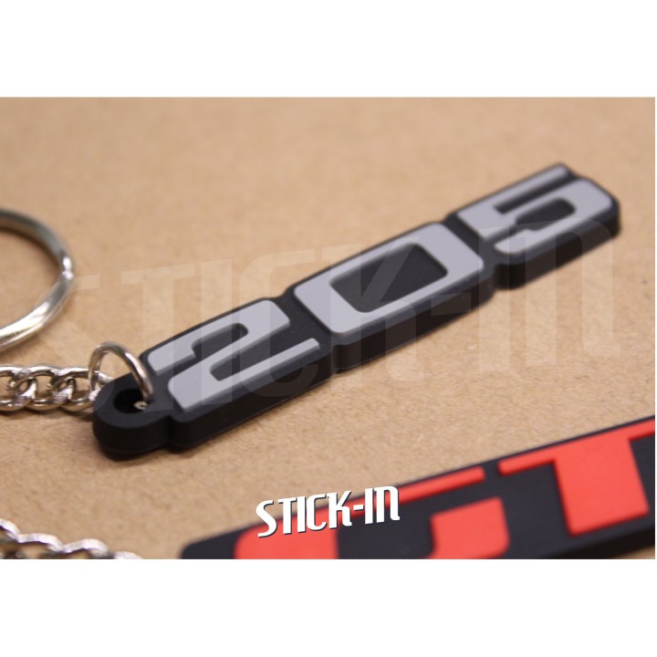 Pack de 2 llaveros Peugeot 205 + GTI de PVC blando con monogramas y logotipos.